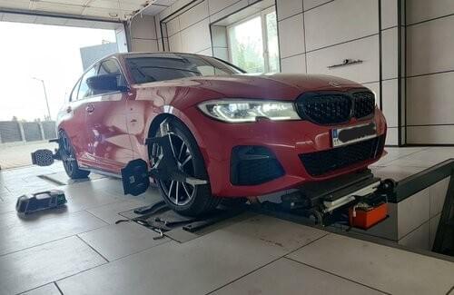 BMW на підйомнику з встановленими датчиками стенду 3D розвалу-сходження в боксі СТО